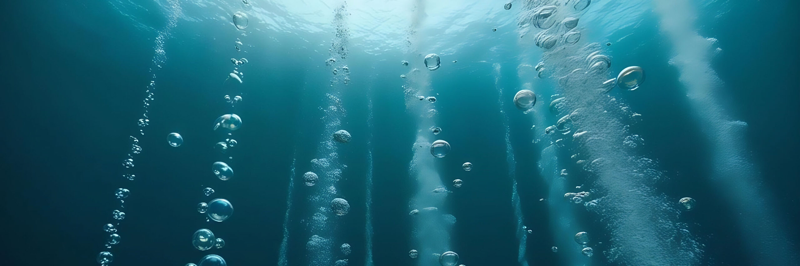 Burbujeo bajo el agua cristalina, representando oxigenación, tratamiento y regeneración de aguas.